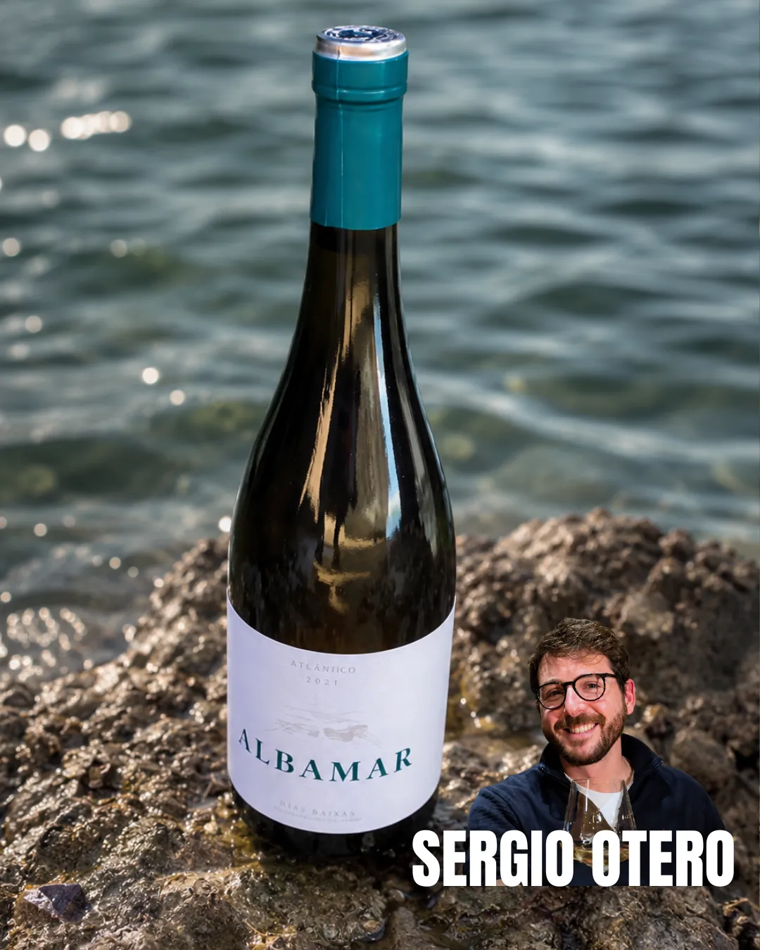 Botella de Albamar Atlántico Rías Baixas en un entorno de rocas marinas junto al sumiller Sergio Otero